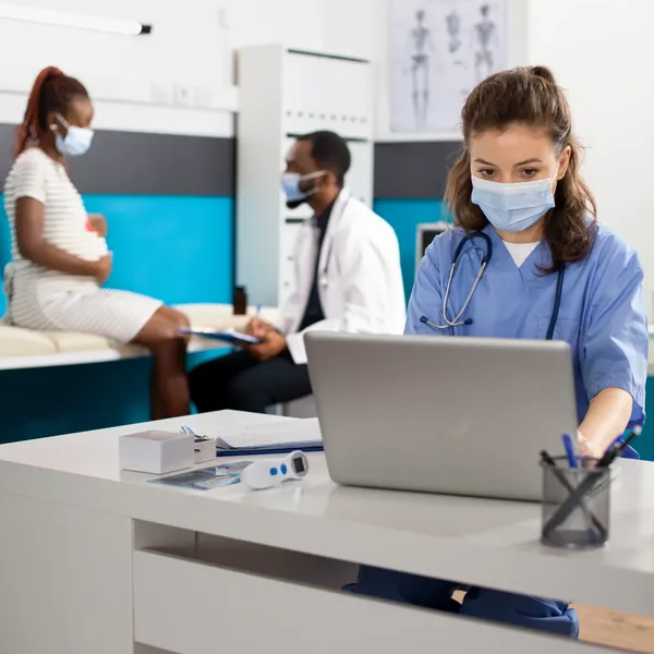 A nurse working on a laptop