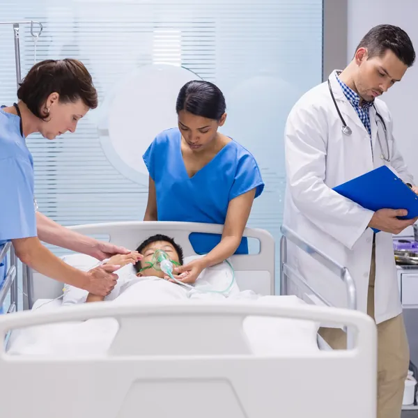 Doctors examining a patient in a ward