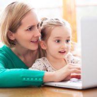 Mother and daughter using a laptop to surf the internet together