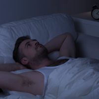 Man with insomnia looking at the ceiling instead of sleeping